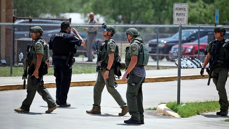 Law enforcement personnel stand outside Robb Elementary School following a shooting, Tuesday, May 24, 2022, in Uvalde, Texas.