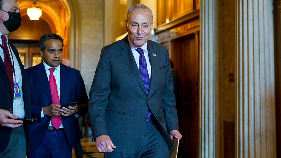 Majority Leader Charles Schumer (D-N.Y.) speaks to a reporter before the weekly Senate Democratic policy luncheon on Wednesday, May 18, 2022.