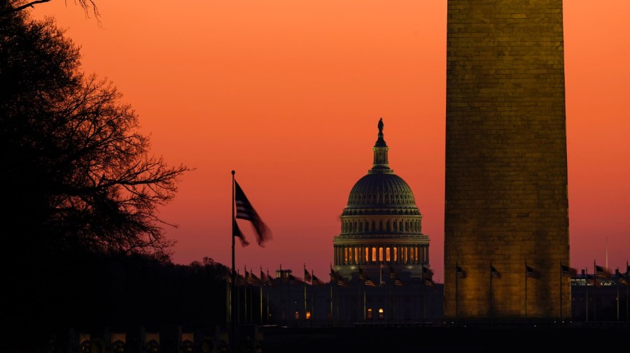 The Capitol is seen beyond the base of the Washington Monument before sunrise in Washington