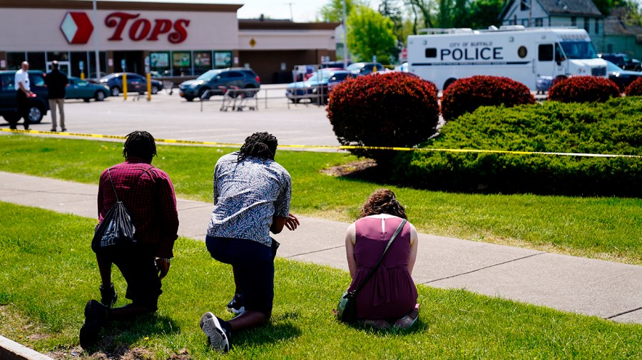 People pray outside the scene of the Buffalo shooting