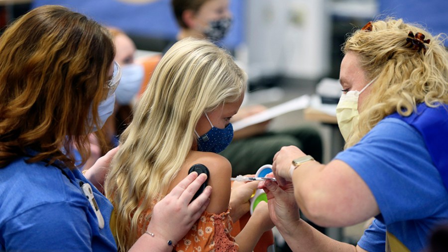 Harper Stukus, 8, receives a Pfizer COVID-19 vaccine from registered nurse Wendy Snyder.