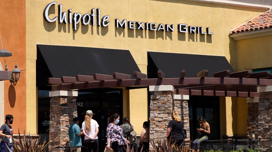 People wait outside a Chipotle Mexican Grill restaurant in Simi Valley, Calif. 