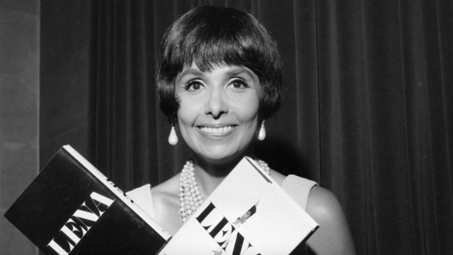 Lena Horne poses with copies of her autobiography "Lena" at a New York dinner in 1965.