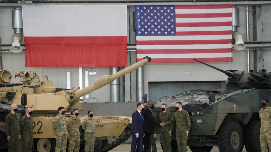 U.S. Defense Secretary Lloyd Austin and Polish Defense Minister Mariusz Blaszczak shake hands with soldiers during a visit with U.S. troops at the Powidz Air Base in Poland.