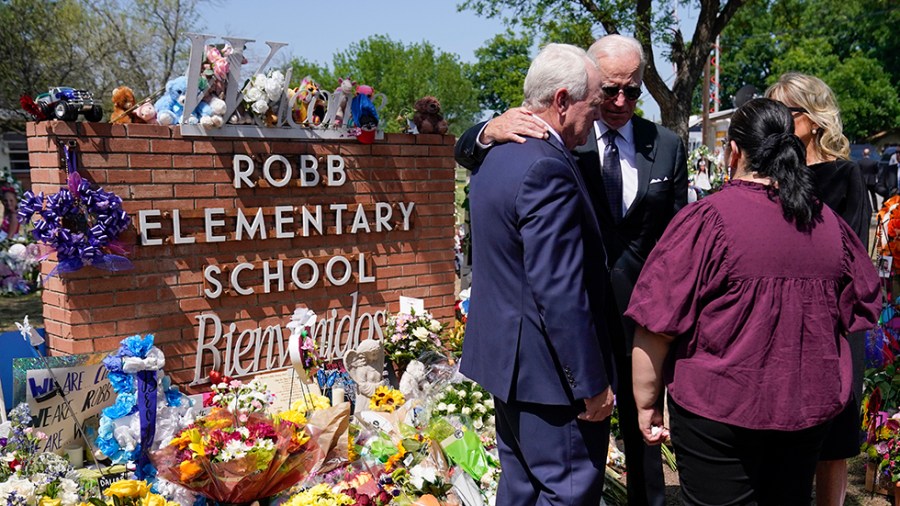 President Biden and first lady Jill Biden talk with school officials next to the Robb Elementary School sign