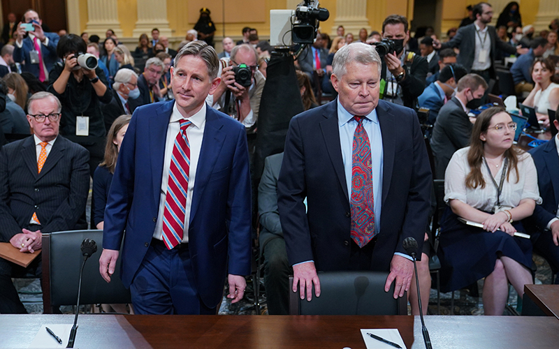 Greg Jacob, left, and J. Michael Luttig , right, stand in front of members of the media and other Jan. 6 hearing attendees