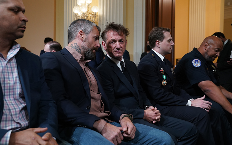 Actor Sean Penn sits as he speaks to former Metropolitan Police Officer Michael Fanone