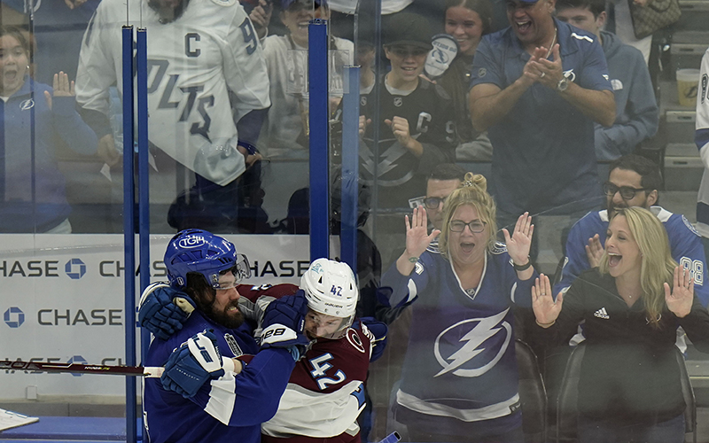 Tampa Bay Lightning left wing Pat Maroon and Colorado Avalanche defenseman Josh Manson scuffle as a crowd behind glass cheers them on