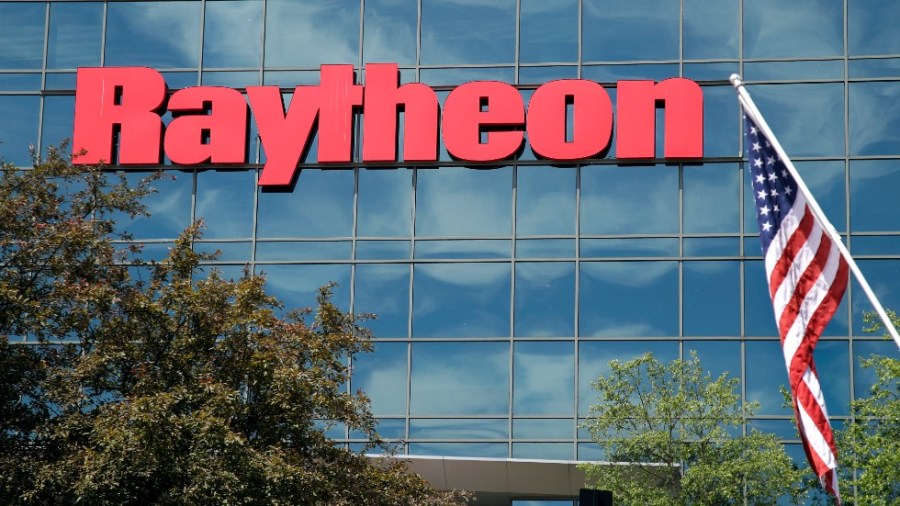 An American flag flies in front of the facade of Raytheon's Integrated Defense Systems facility, in Woburn, Mass.