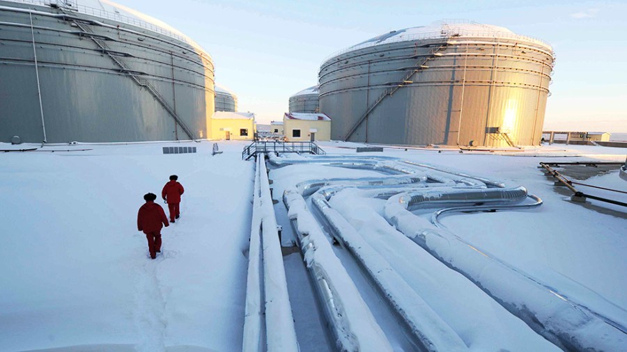 Workers inspect pipelines and oil storage tanks