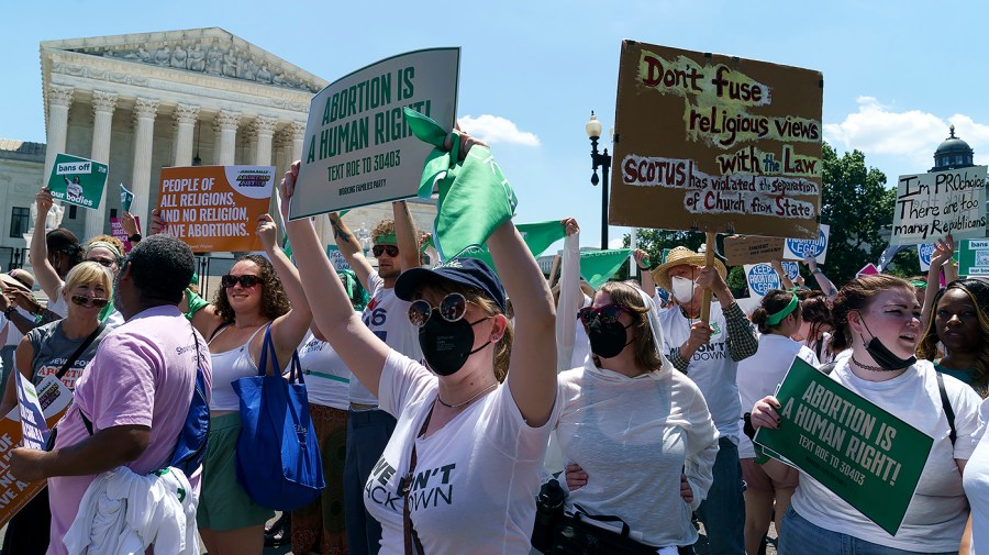 Protesters for abortion rights pass by the Supreme Court before conducting a non-violent protest outside the Senate office buildings on Thursday, June 30, 2022.