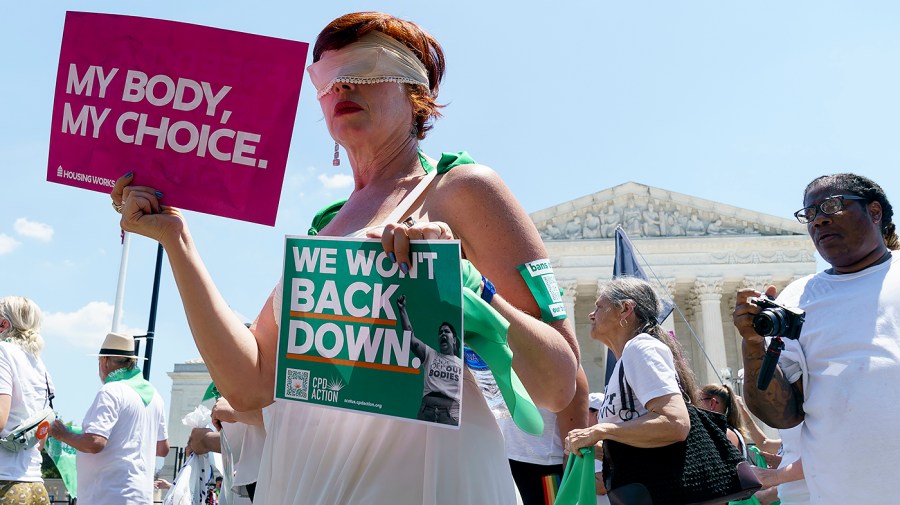 Protesters for abortion rights pass by the Supreme Court before conducting a non-violent protest outside the Senate office buildings on Thursday, June 30, 2022.