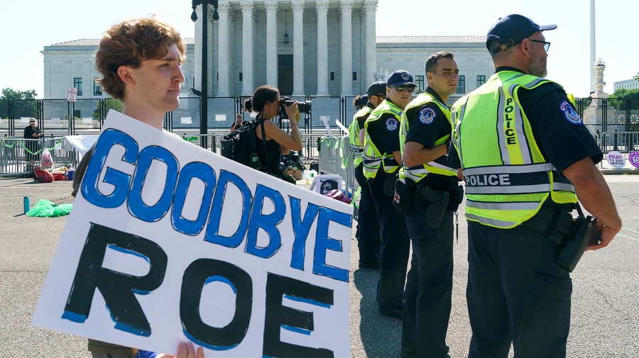 U.S. Capitol Police Officers observe a supporter who opposes abortion arrive at the Supreme Court on Wednesday, June 15, 2022 as the Court is set to release several opinions.