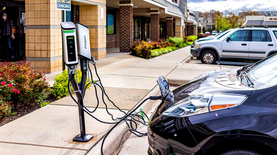 An electric vehicle charges in front of a store.