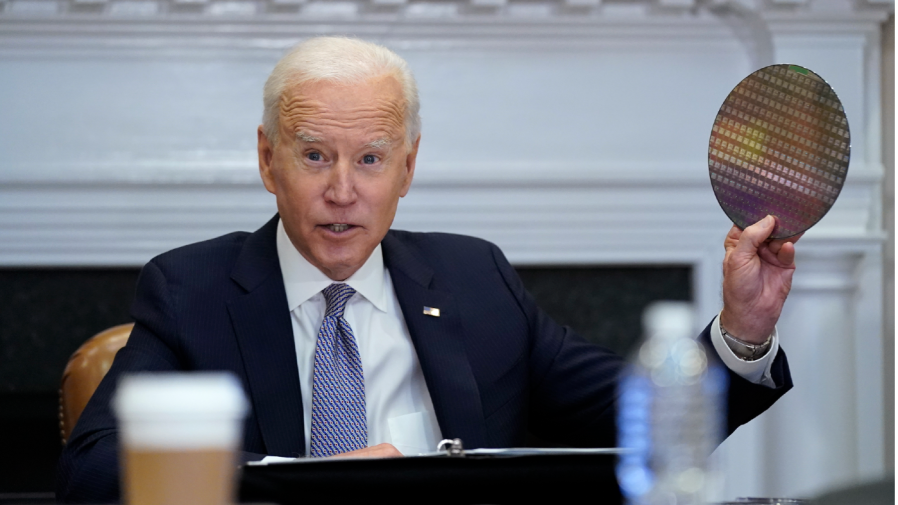 President Joe Biden holds up a silicon wafer as he participates virtually in the CEO Summit on Semiconductor and Supply Chain Resilience in the Roosevelt Room of the White House, Monday, April 12, 2021, in Washington.