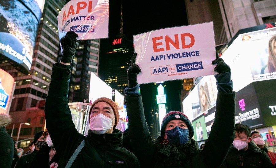 People hold signs in support of Asian American Pacific Islander communities on Jan. 18, 2022, in New York.