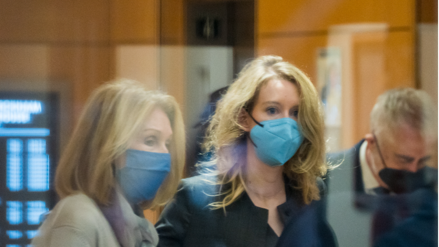 Elizabeth Holmes, center, enters federal court in San Jose, Calif., Monday, Jan. 3, 2022.