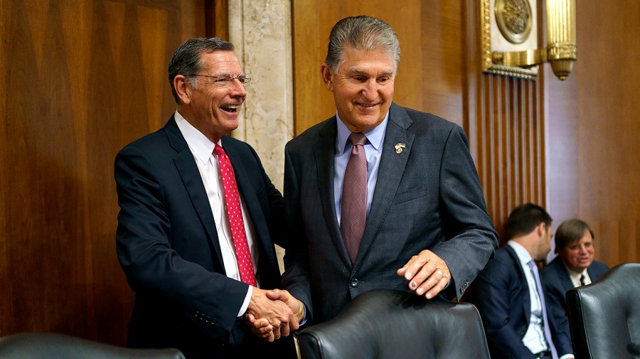 Sen. John Barrasso (R-Wyo.) greets Senate Energy and Natural Resources Committee Chairman Joe Manchin (D-W.Va.) before a hearing to discuss federal regulatory authorities governing the development of interstate hydrogen pipelines, storage, import, and export facilities on Tuesday, July 19, 2022.