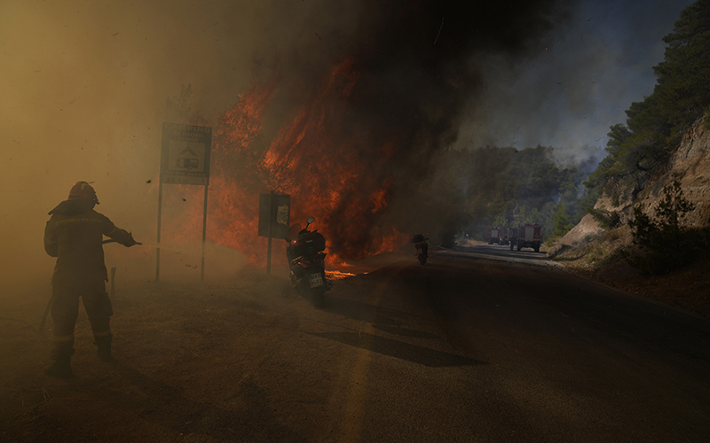 A firefighter tries to extinguish the flames next to motorcycles