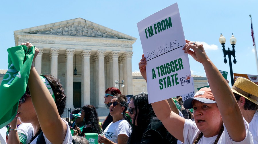 Protesters for abortion rights pass by the Supreme Court before conducting a non-violent protest outside the Senate office buildings on Thursday, June 30, 2022.