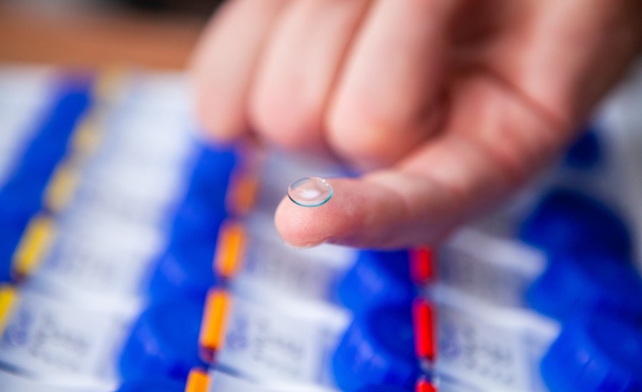 hand with a contact lens on tip of pointer finger