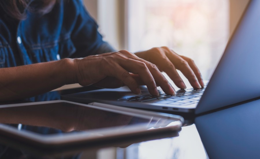 A person types on a laptop.