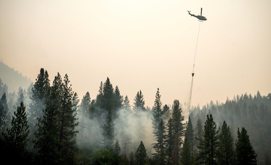 A helicopter drops water on the McKinney Fire in California.