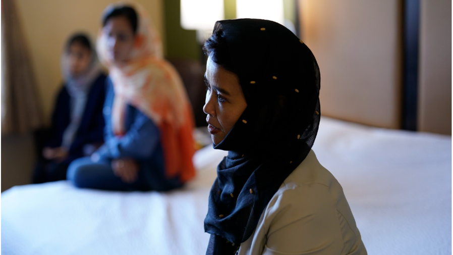 Gulsom Esmaelzade, 35, right, sits with her sisters, Shoriya Esmaelzade, 34, left, and Susan Esmaelzade, 28, in a hotel room where Susan sleeps, Wednesday, May 4, 2022, in San Diego.