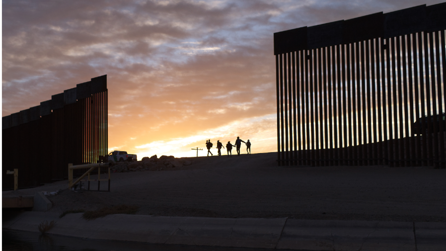 FILE - In this Thursday, June 10, 2021, file photo, a pair of migrant families from Brazil pass through a gap in the border wall to reach the United States after crossing from Mexico to Yuma, Ariz., to seek asylum.