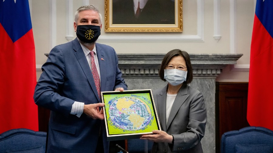 In this photo released by the Taiwan Presidential Office, Taiwan's President Tsai Ing-wen at right exchanges gifts with U.S. Indiana Governor Eric Holcomb during a meeting at the Presidential office in Taipei.