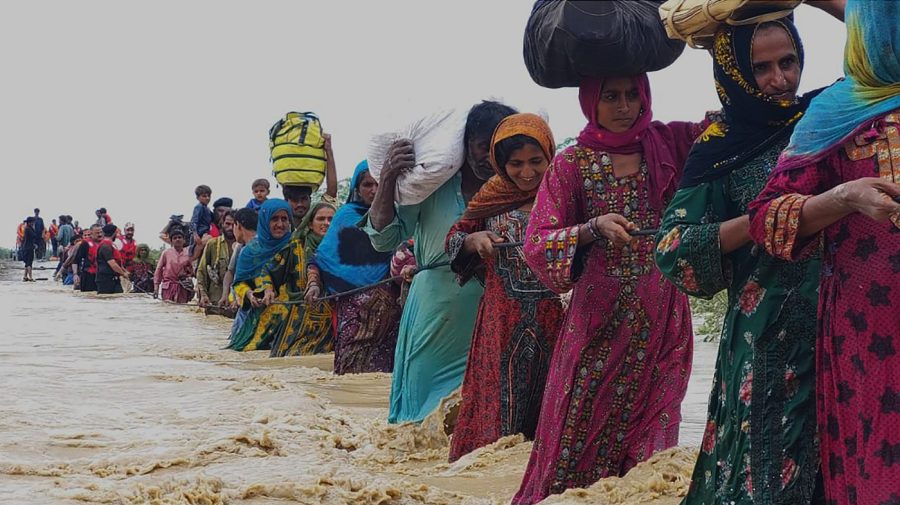 Rescue workers help villagers to evacuate them from flooded area caused by heavy rains, in Lasbella, a district in Pakistan's southwest Baluchistan province, Tuesday, July 26, 2022.