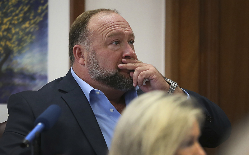 Alex Jones attempts to answer questions during his trial