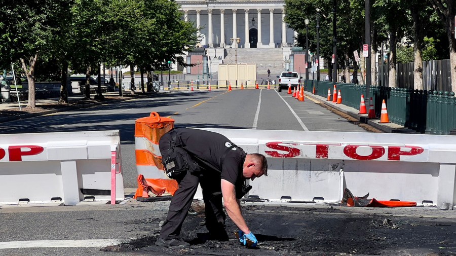 A U.S. Capitol Police officer works near a police barricade on Capitol Hill