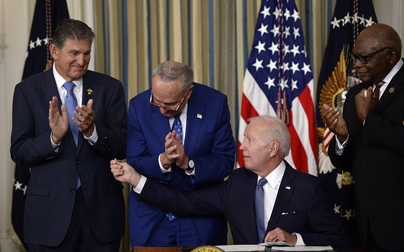 President Biden hands Sen. Joe Manchin (D-W.Va.) a pen