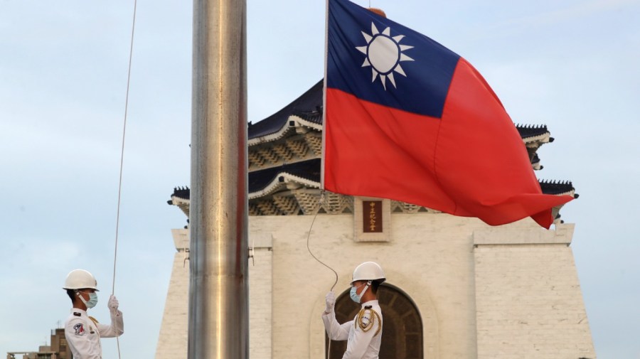 Two soldiers lower the national flag during the daily flag ceremony on the Liberty Square of Chiang Kai-shek Memorial Hall in Taipei, Taiwan.