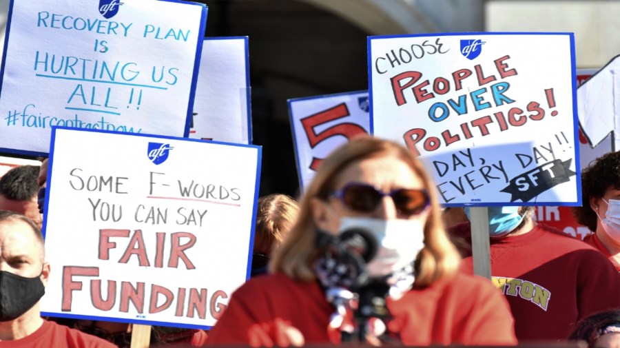 Rosemary Boland, president of the Scranton Federation of Teachers, speaks at a rally of striking Scranton teachers holding signs behind her at the Pennsylvania Capitol, Wednesday, Nov. 10, 2021, in Harrisburg, Pa.