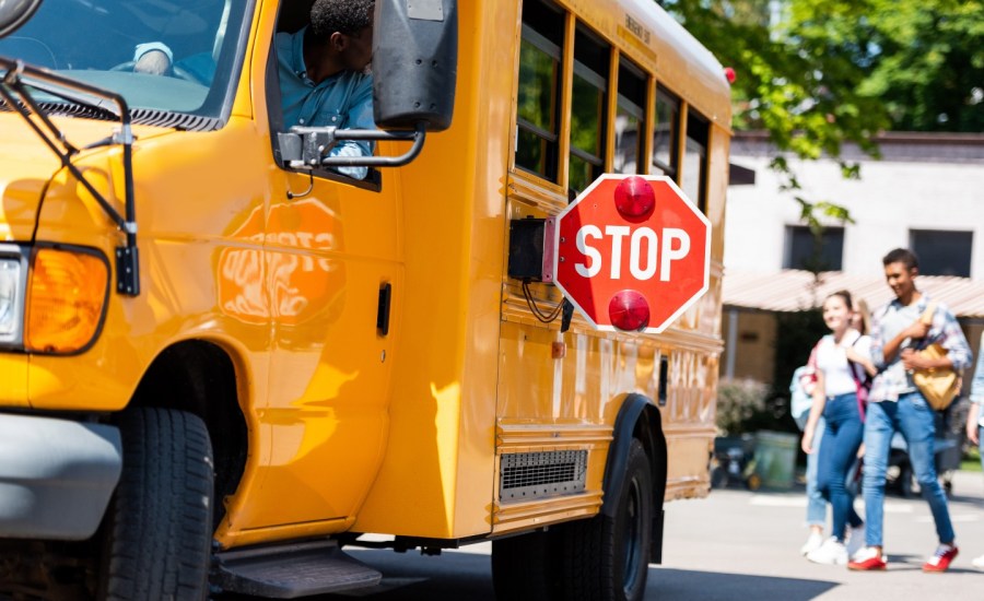 school bus with children or teenagers in the background