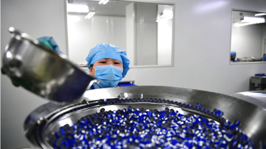 In this photo released by Xinhua News Agency, a staff member works at the workshop of Fusen Pharmaceutical Co., Ltd. in Nanyang in central China's Henan Province, Thursday Feb. 20, 2020.