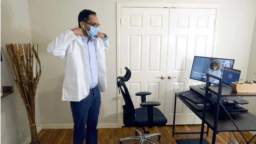 FILE - Medical director of Doctor on Demand Dr. Vibin Roy prepares to conduct an online visit with a patient from his work station at home, April 23, 2021, in Keller, Texas.