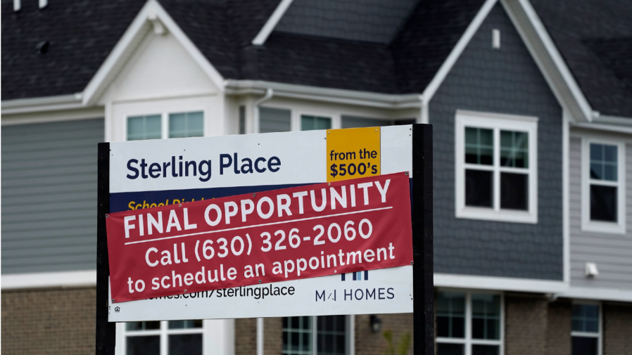 An advertising sign for building land stands in front of a new home construction site in Northbrook, Ill., Thursday, May 5, 2022.