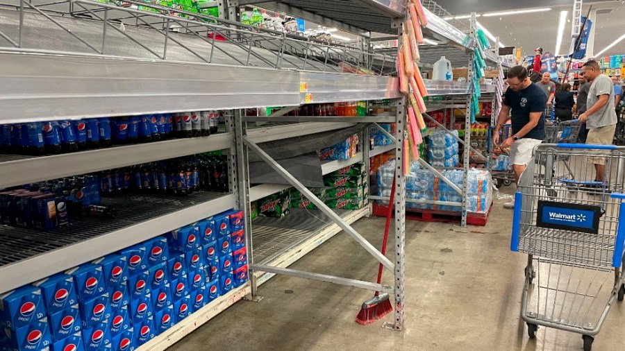 Shoppers go for what was left of the water on the shelves of the Walmart Supercenter at 1505 N. Dale Mabry Highway on Sunday, Sept. 25, 2022, in Tampa, Fla., as Tropical Storm Ian threatened to impact the Tampa Bay as a major hurricane later in the week.