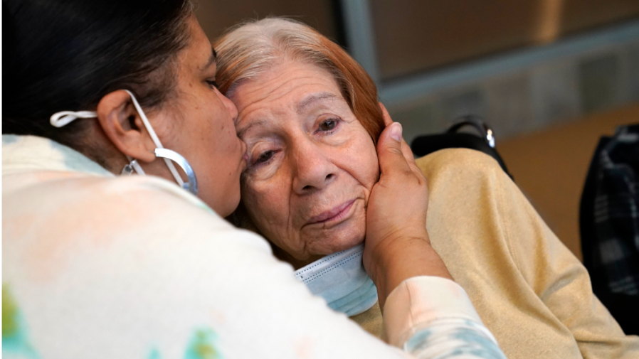 FILE - Rosa DeSoto, left, embraces her 93-year-old mother Gloria DeSoto, who suffers from dementia, inside the Hebrew Home at Riverdale, Sunday, March 28, 2021, in the Bronx borough of New York.