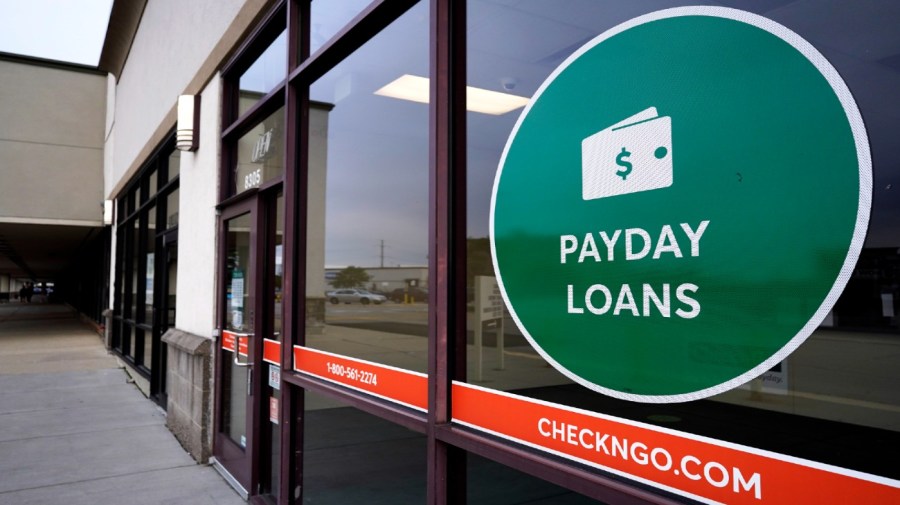 A "Payday Loans" sign is displayed at a Check'n Go in Niles, Ill., Sunday, July 11, 2021.