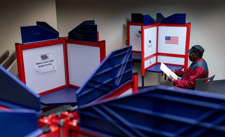 voting dividers on tables and person sitting looking at paper