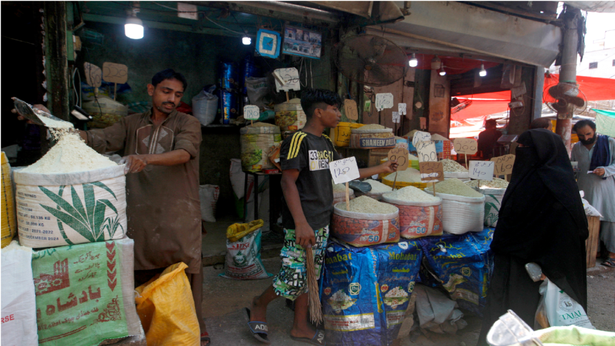 A woman prices foodstuff from a shopkeeper at a market, in Karachi, Pakistan, Thursday, July 14, 2022.