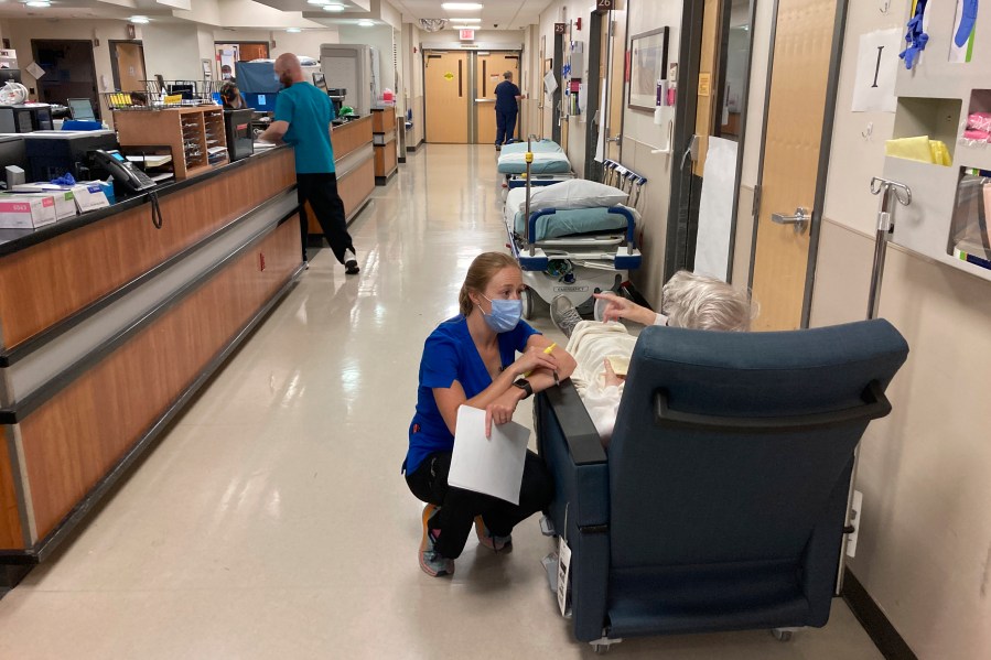 A nurse talks to a patient in the emergency room