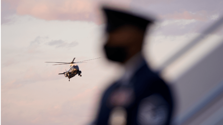 FILE - In this Feb. 5, 2021, file photo Marine One, with President Joe Biden aboard, is seen past a member of the U.S. Air Force as it approaches Andrews Air Force Base, Md.