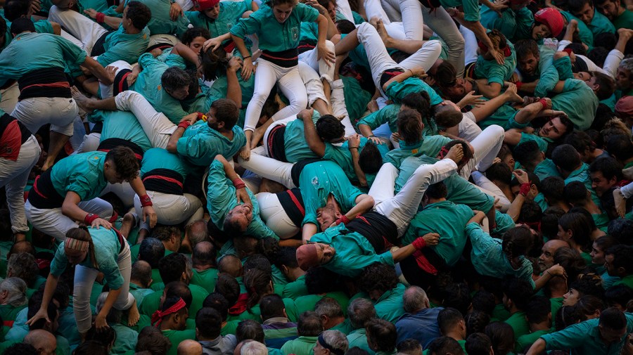 A group of people falls as they try to complete a human tower