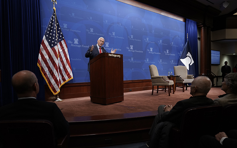 Former Vice President Mike Pence standing at a podium speaks to people in the audience at the Heritage Foundation