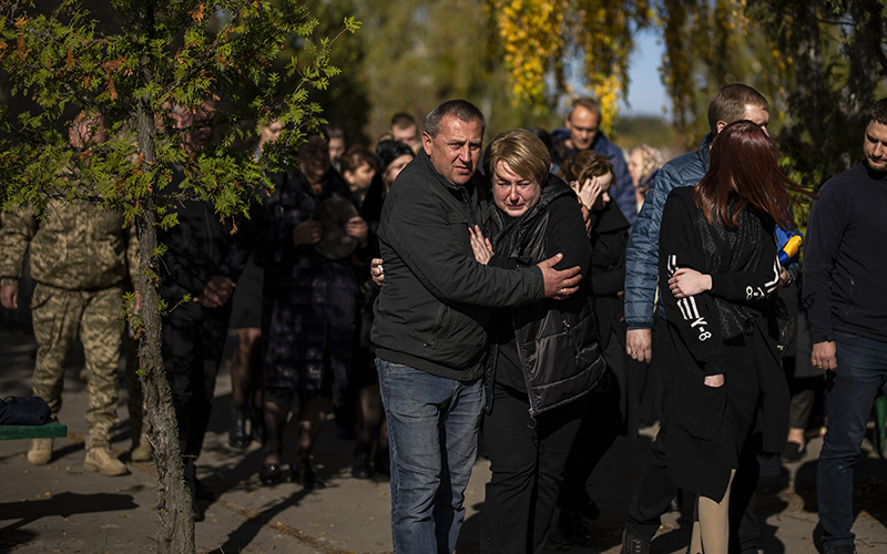 Relatives mourn and hold one another while following the coffin of Col. Oleksiy Telizhenko during his funeral in Bucha, Ukraine